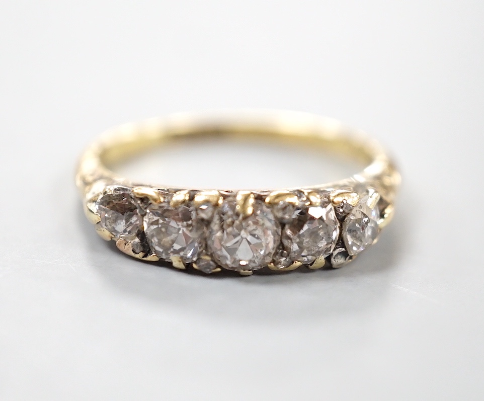 An 18ct and graduated five stone diamond set half hoop ring, size M, gross weight 3.5 grams.